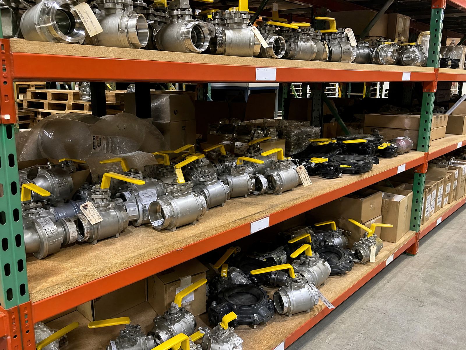 Shelves of surplus ball valves in stainless and carbon steel